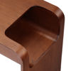 Picture of Walnut Side Table next to  bed slotted over the seat of a sofa otis side table